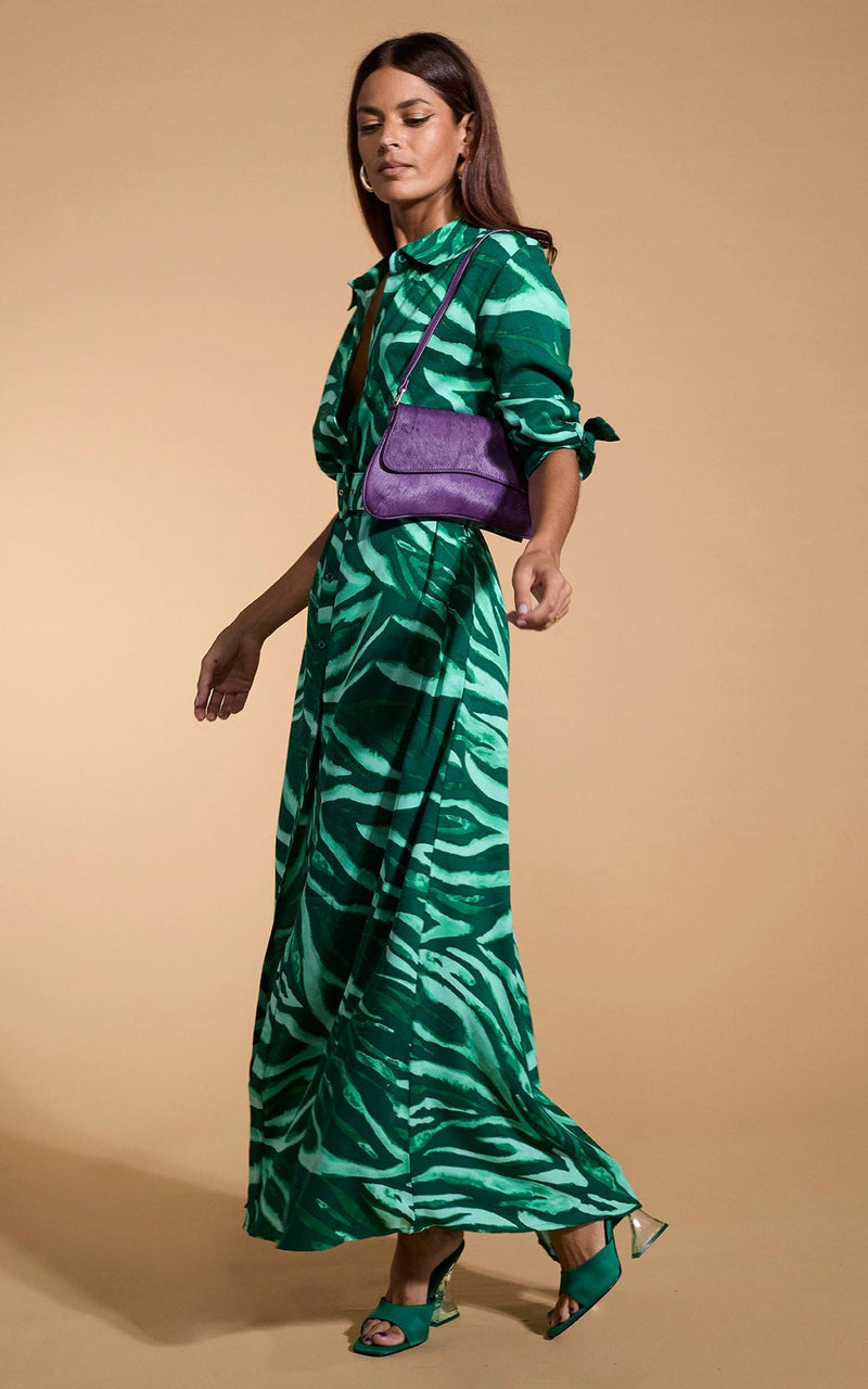 A female model faces forwards. She wears a Dancing Leopard maxi shirt dress, in green zebra print.