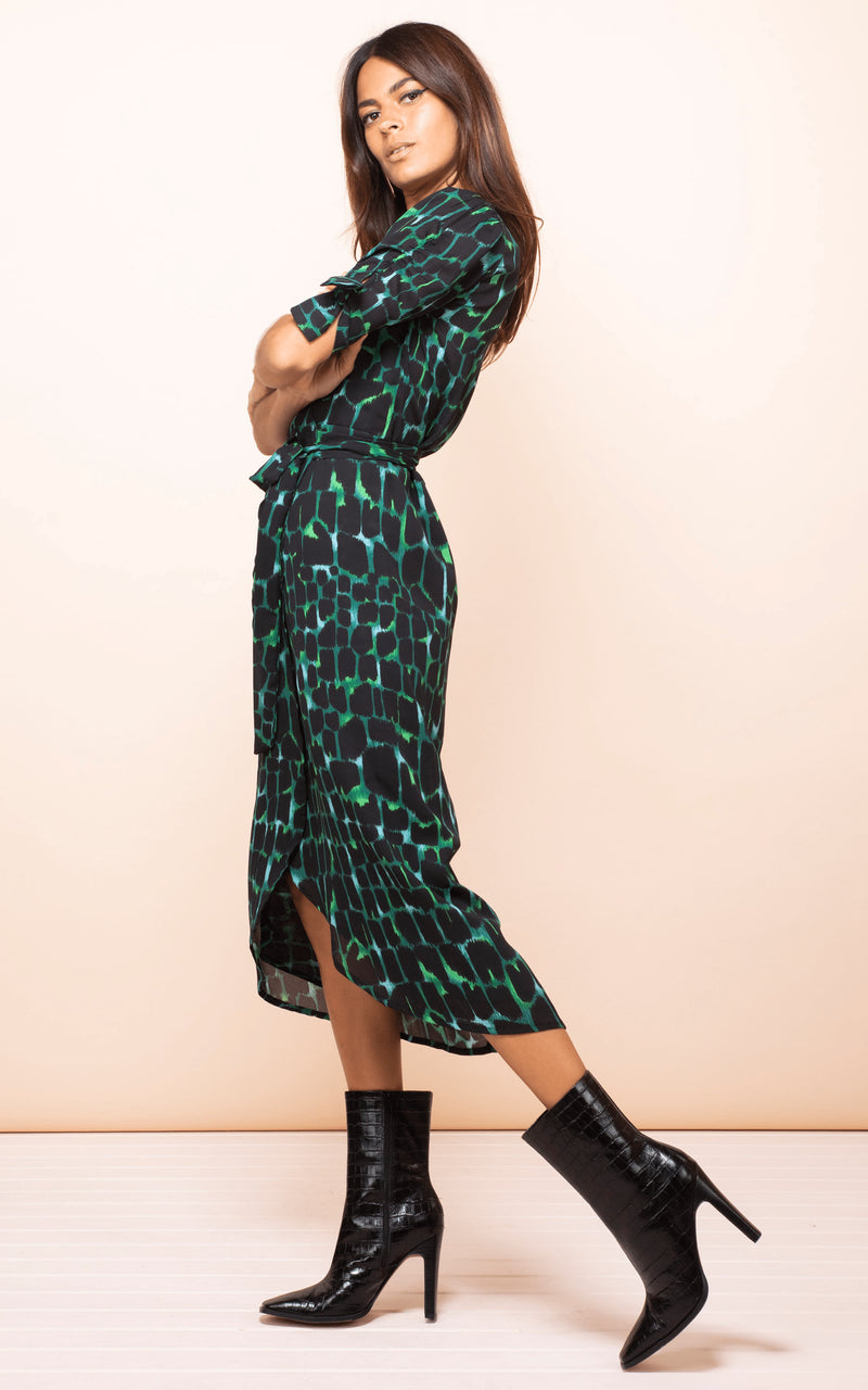 Dancing Leopard model leans back with arms crossed wearing Olivera Midi Dress in green croc print